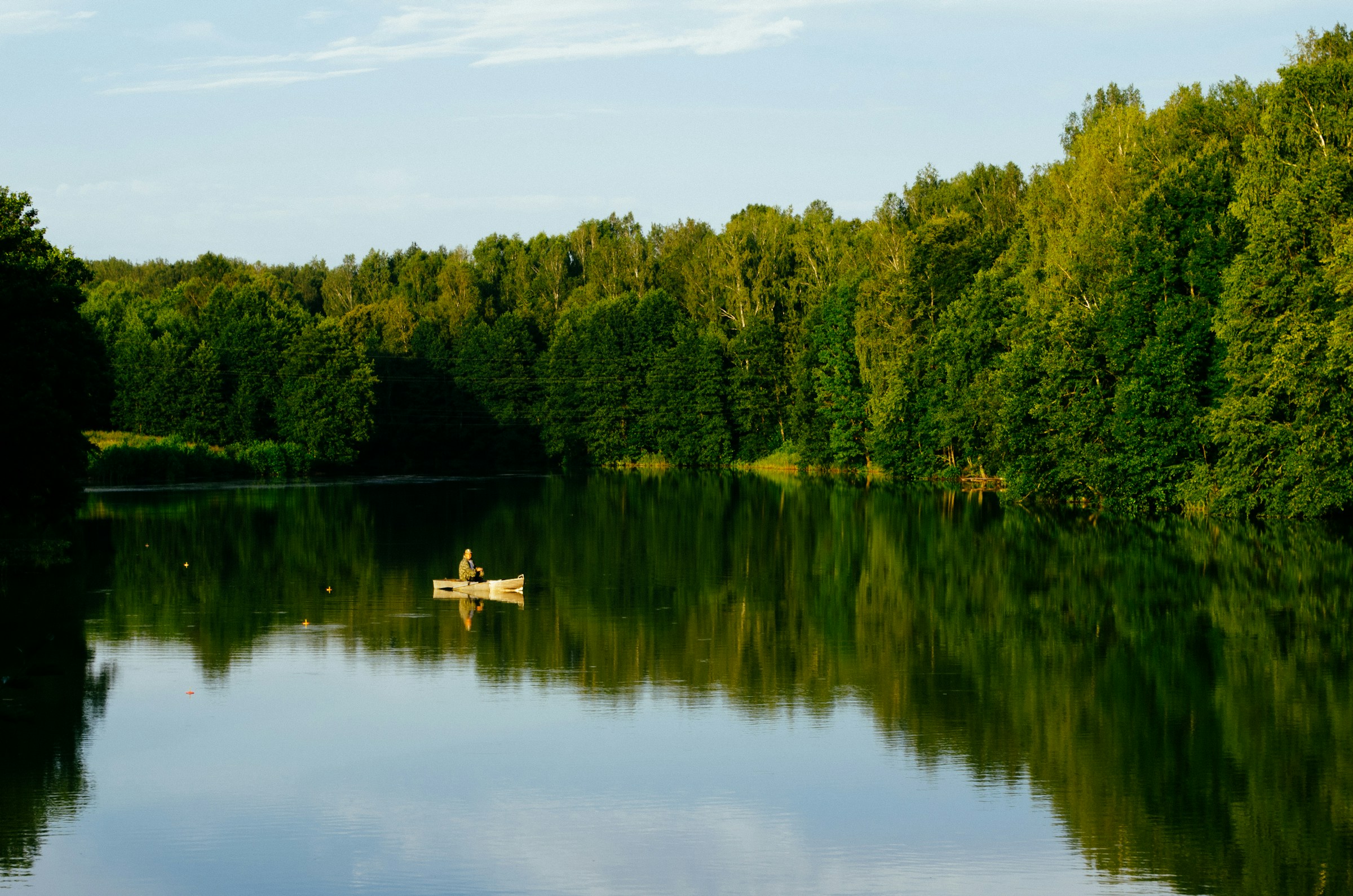 Angler auf einem ruhigen Waldsee